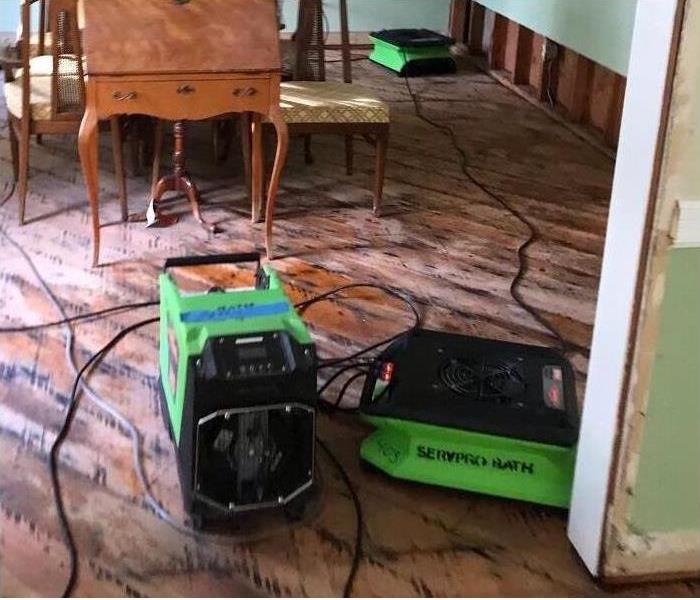 Drying equipment placed on water damaged wooded floors in dining room of local home