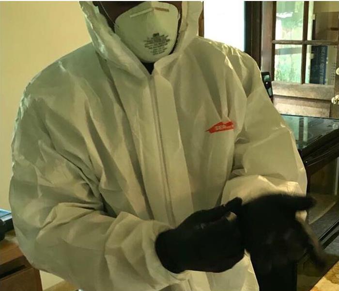 SERVPRO employee utilizing a protective suit to protect him during cleanup